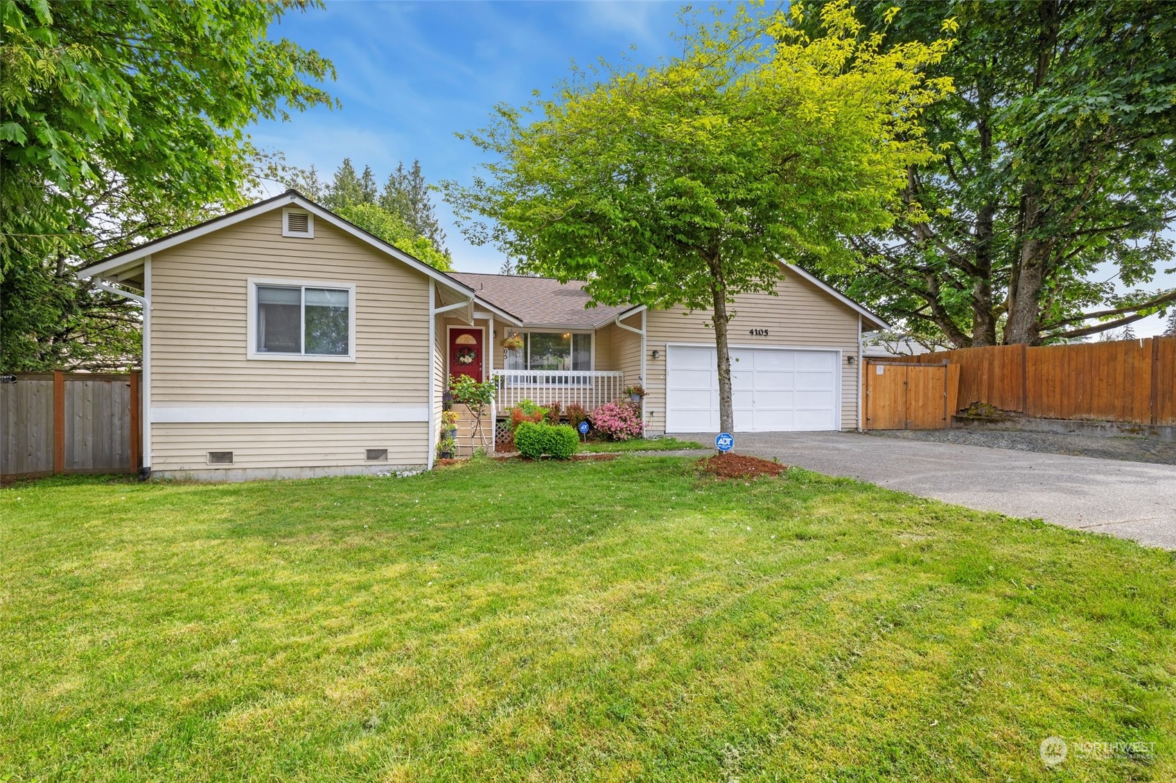 a view of a house with a yard and large tree