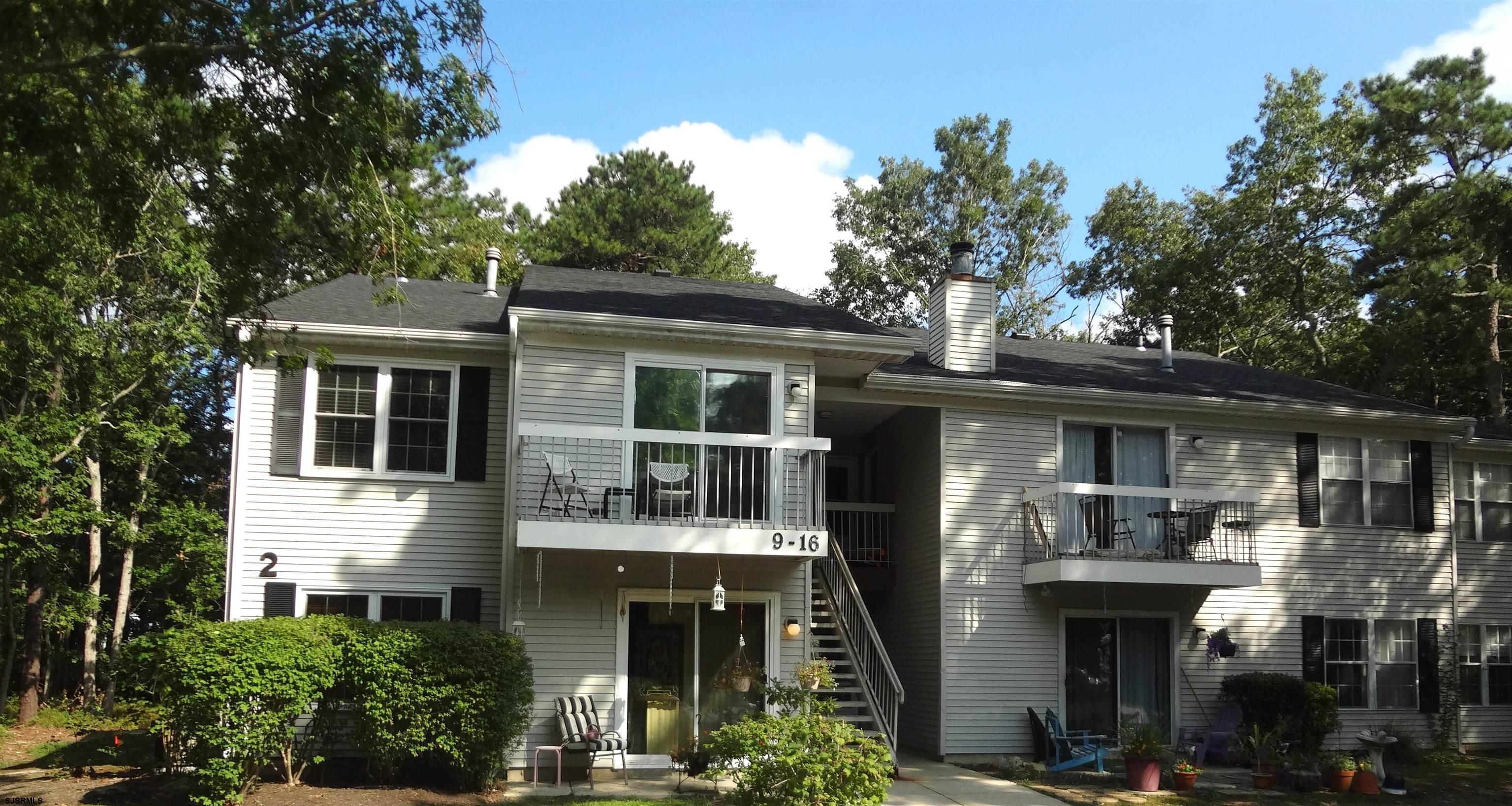 a front view of a house with a tree