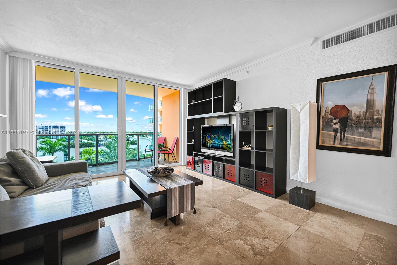 a living room with furniture tv and a floor to ceiling window