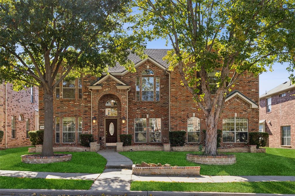 front view of a brick house with a yard