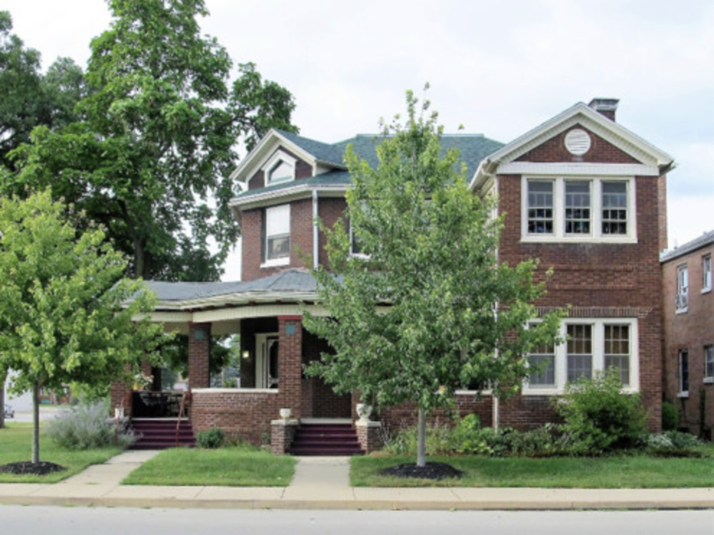 a front view of a house with a yard and potted plants