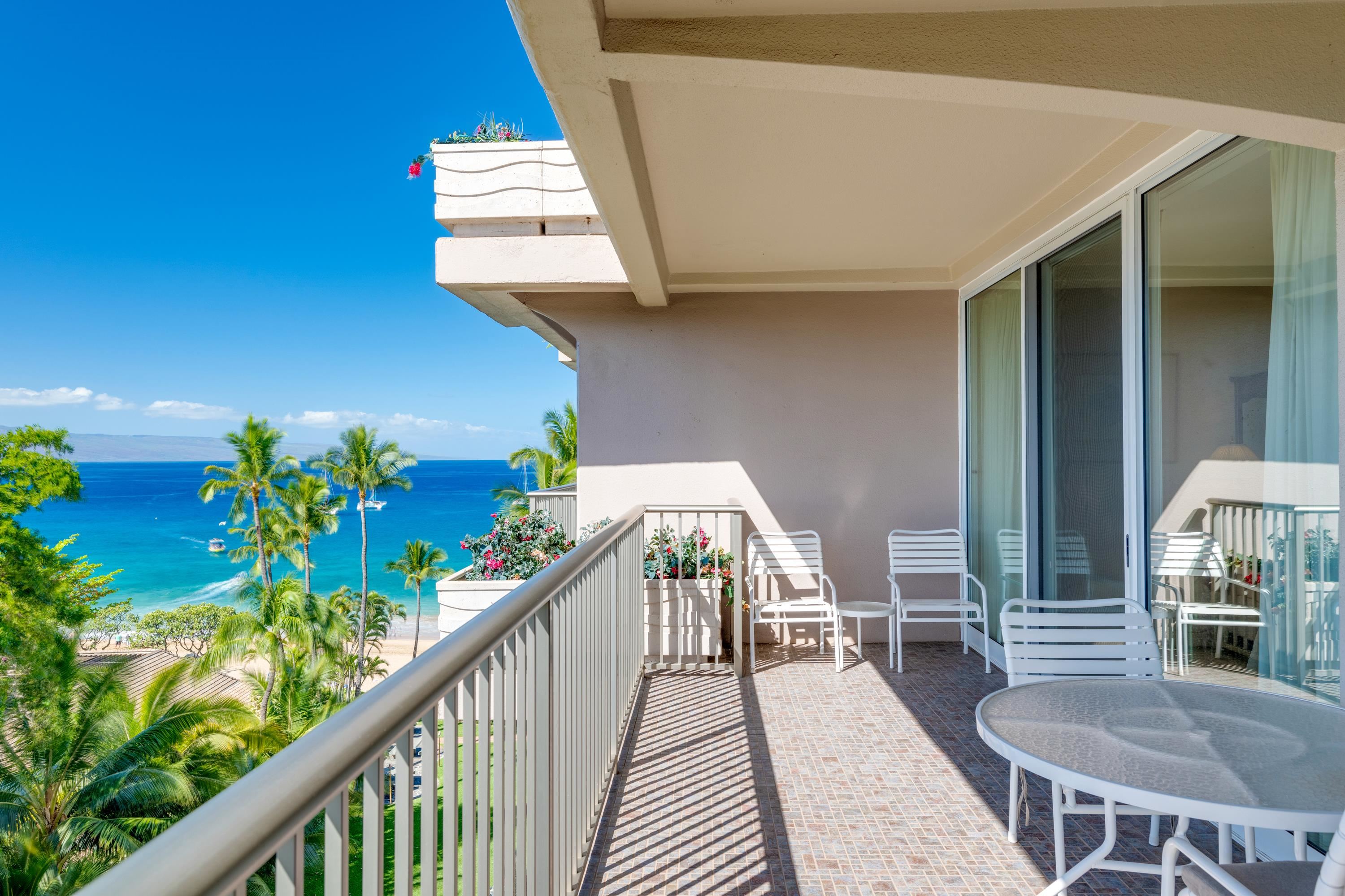 a balcony with wooden floor table and chairs