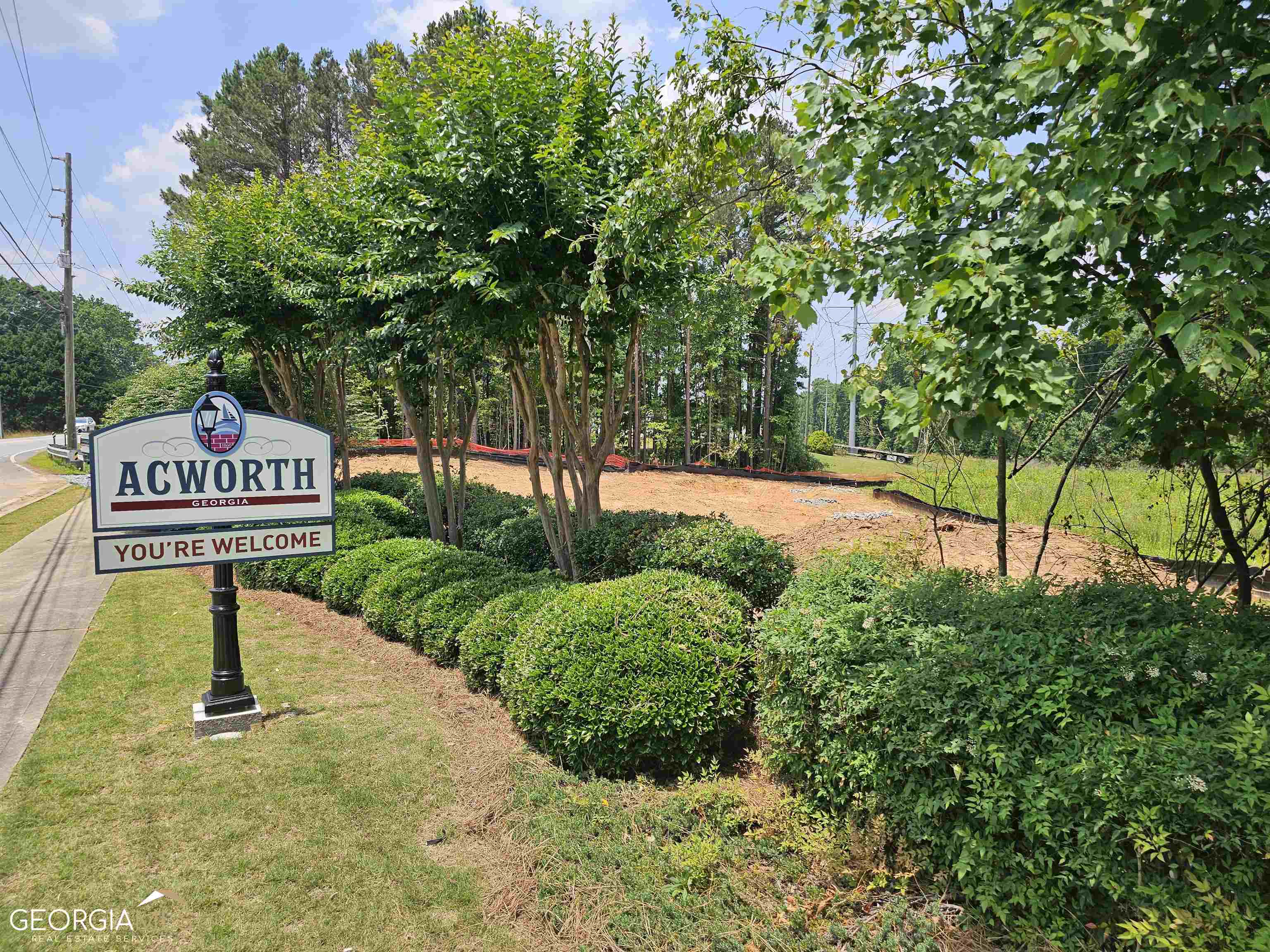 a sign board with a park park bench and trees