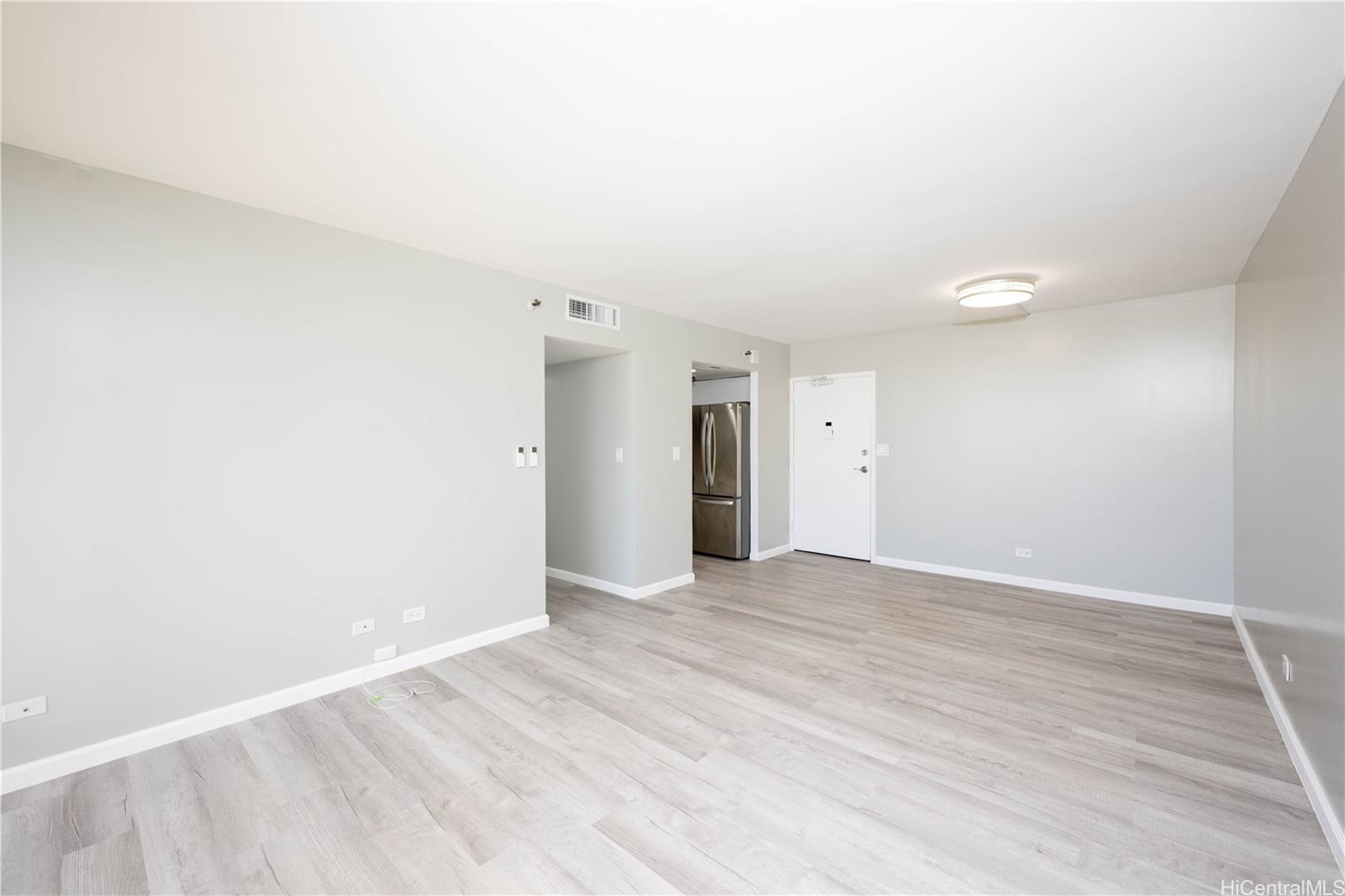 a view of an empty room with wooden floor