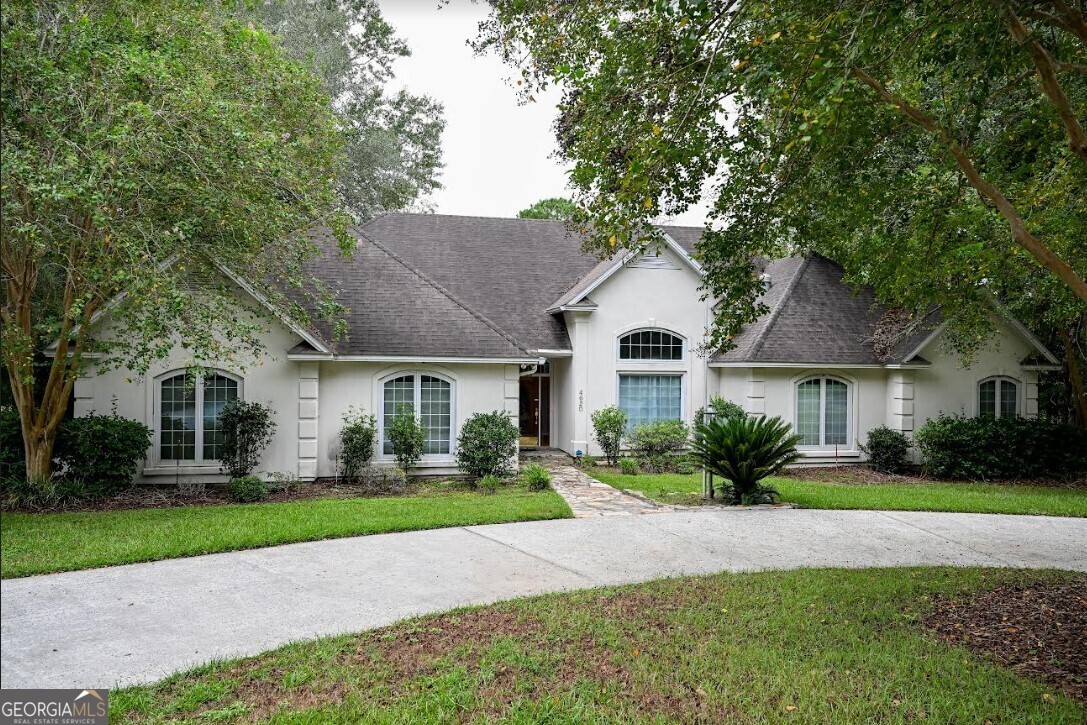 a front view of a house with a yard and trees