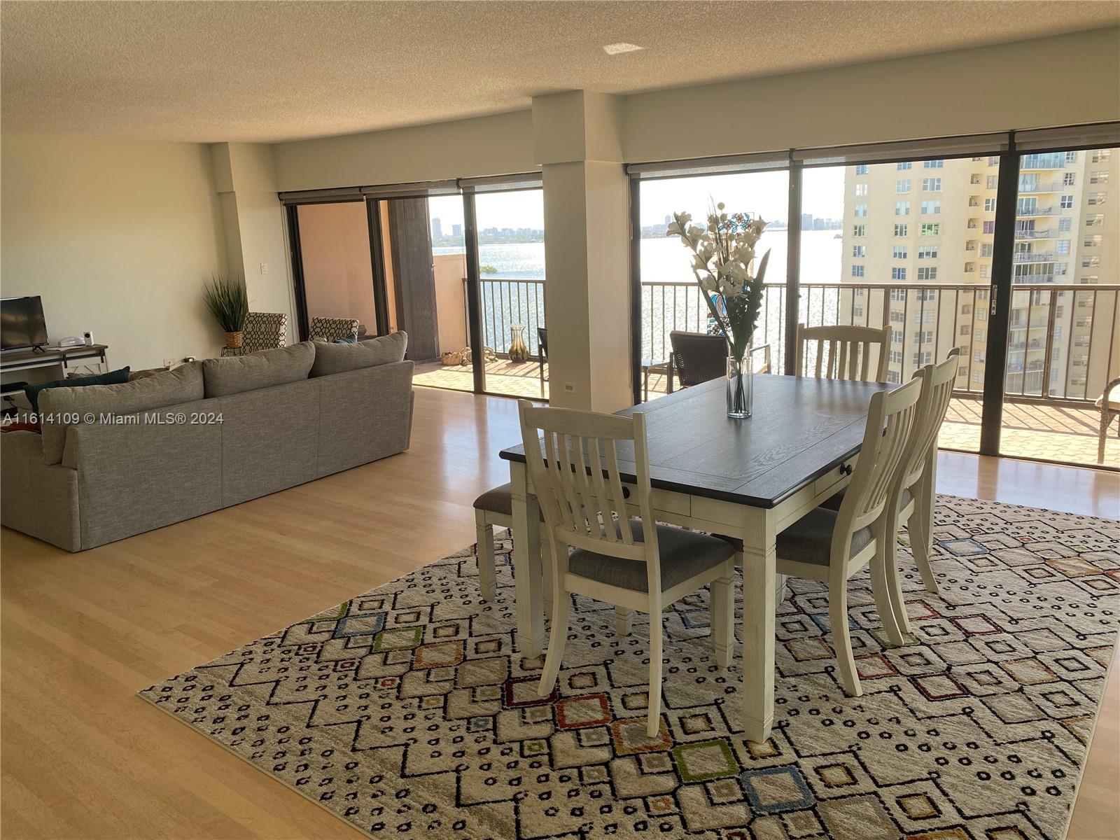 a dining room with furniture a chandelier and wooden floor