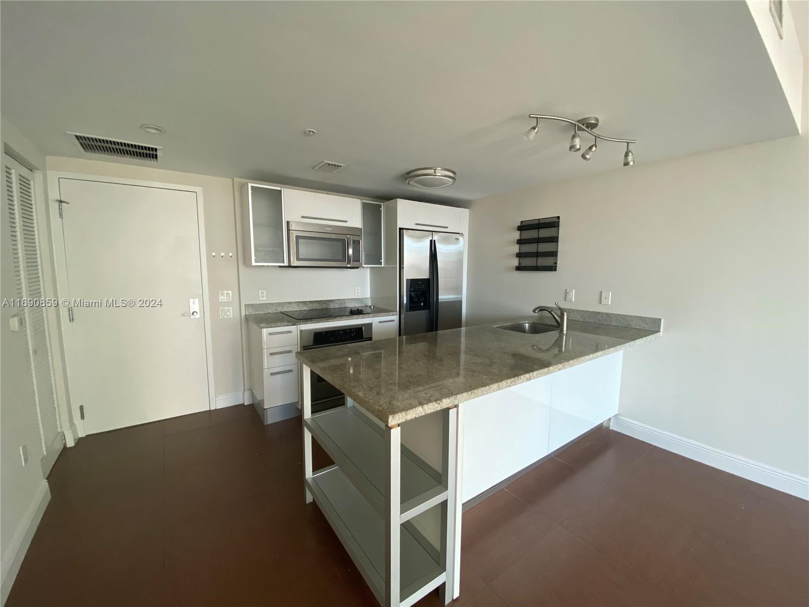 a kitchen with kitchen island a counter top space appliances and cabinets