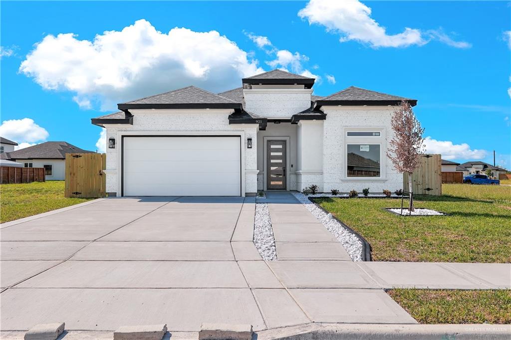 Prairie-style home featuring a garage and a front lawn