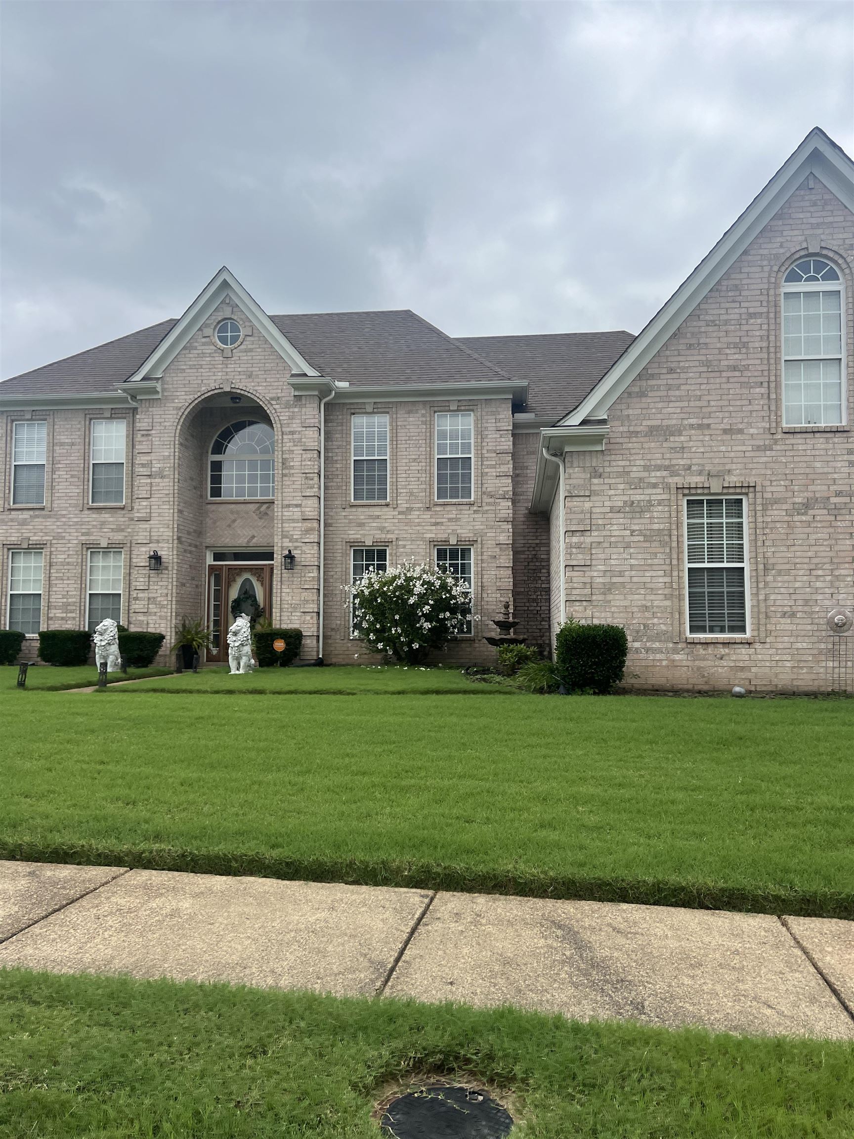 a front view of a house with a garden and yard