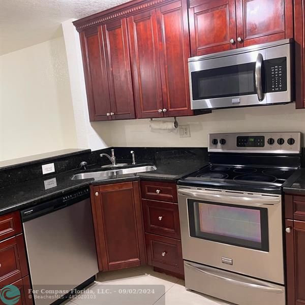 a kitchen with a stove microwave and sink