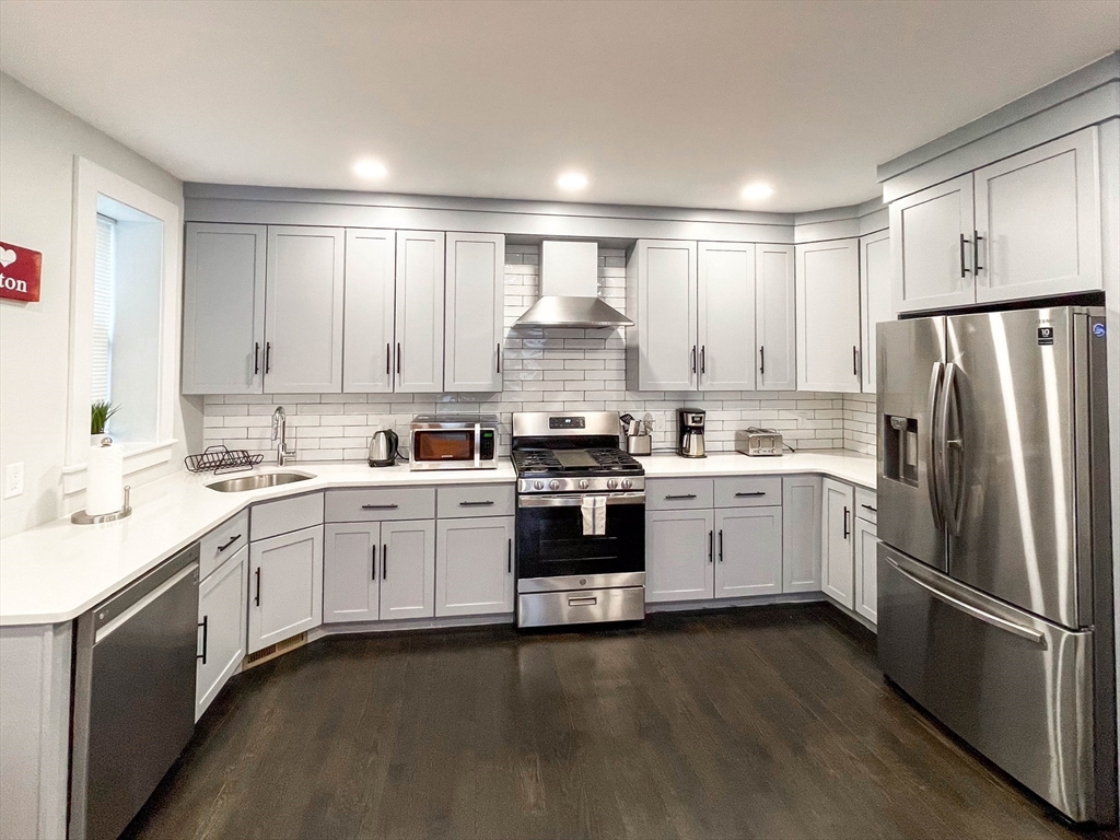 a kitchen with kitchen island granite countertop white cabinets and stainless steel appliances
