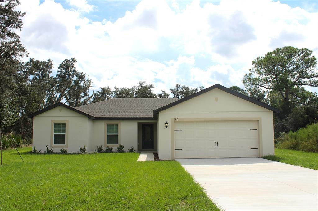 a view of a house with a yard and garage