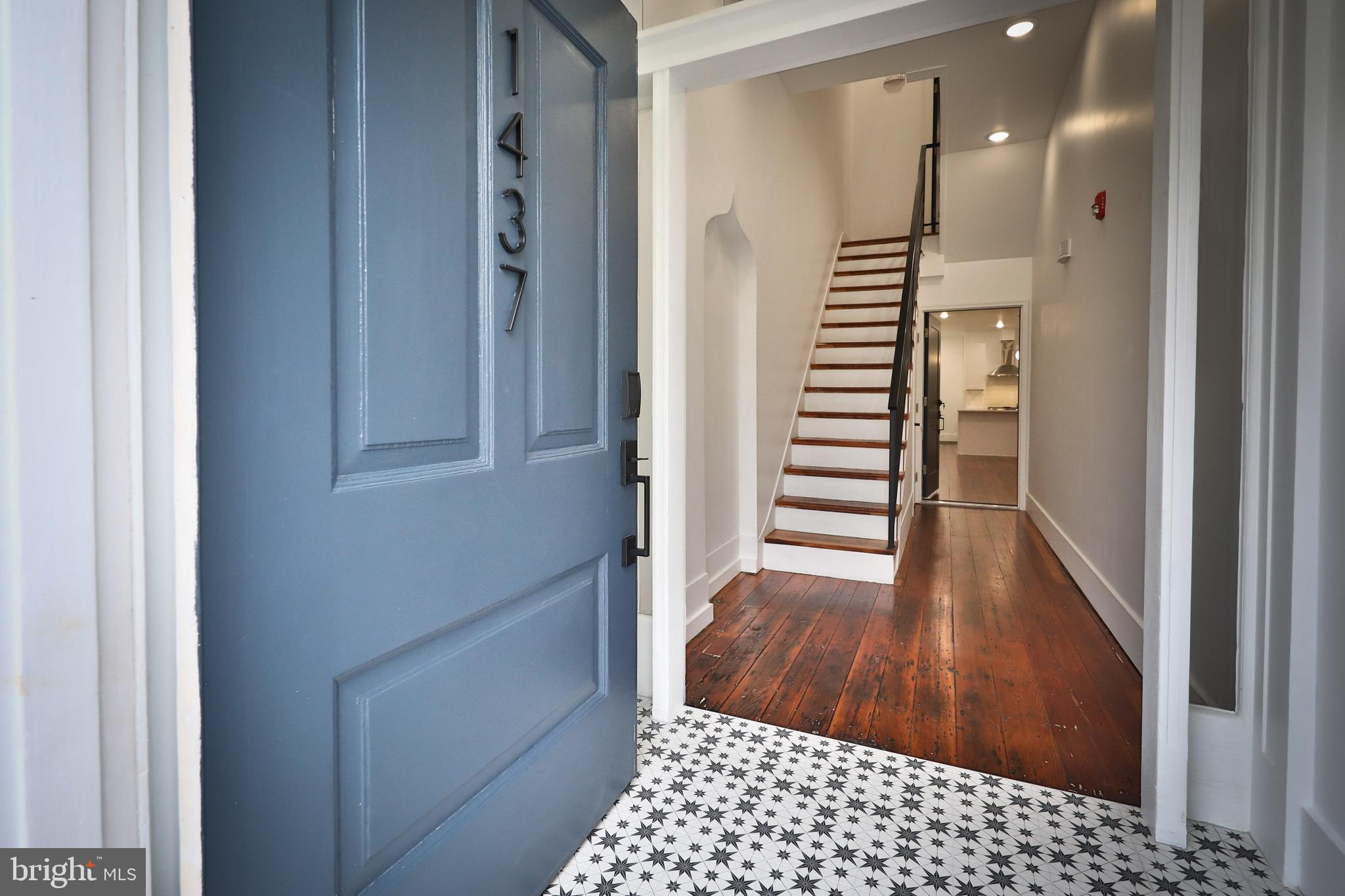 a view of a hallway with wooden floor and staircase