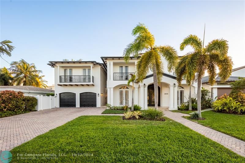 a front view of a house with a yard and palm trees