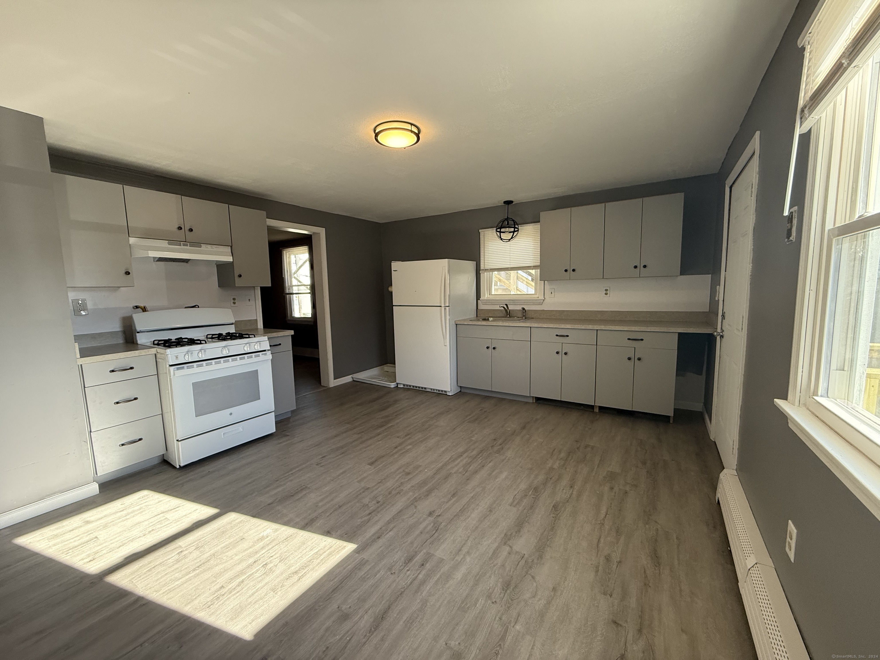 a kitchen with cabinets wooden floor and a sink