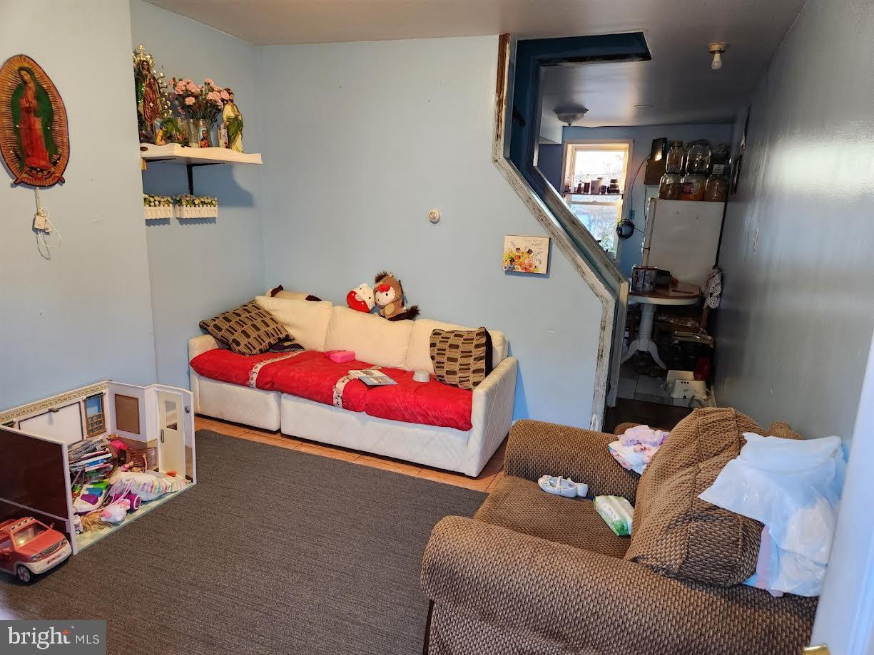 a living room with furniture and a baby crib