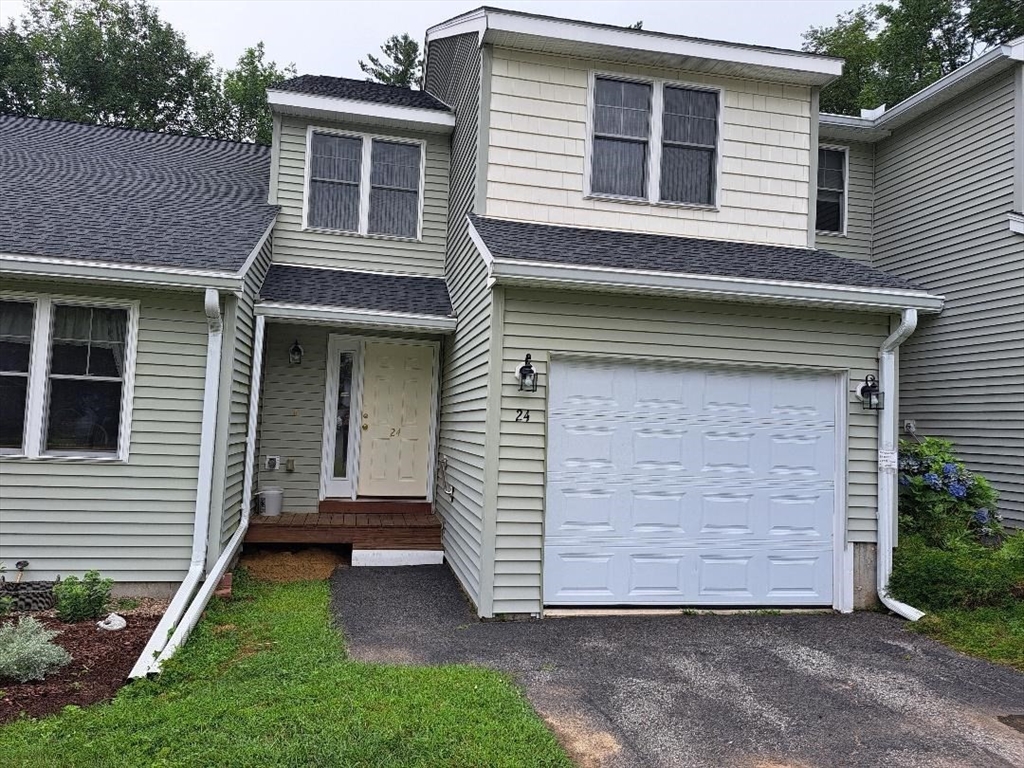 a view of a house with a yard and garage