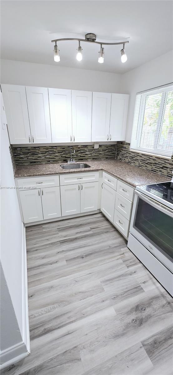 a kitchen with granite countertop white cabinets and white appliances