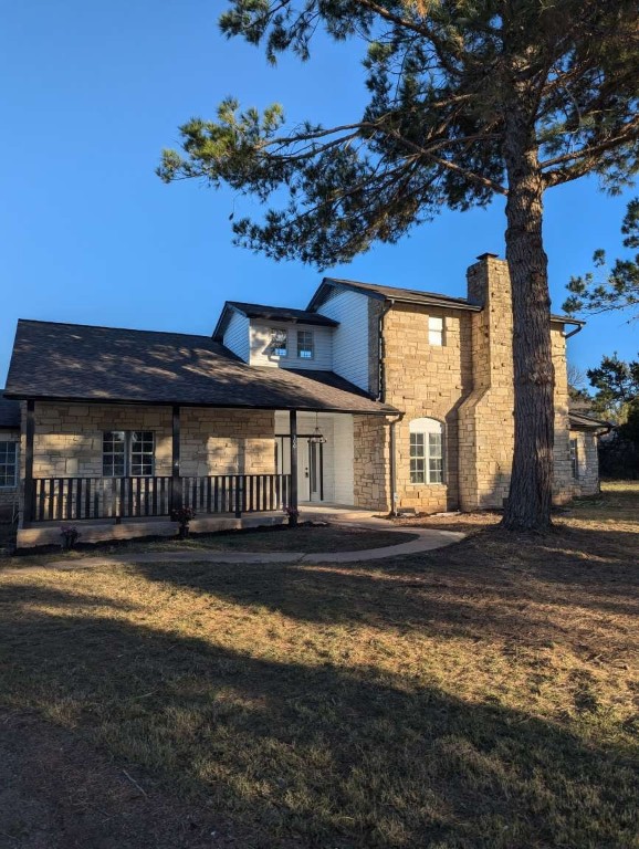 a view of a house with a patio and a yard