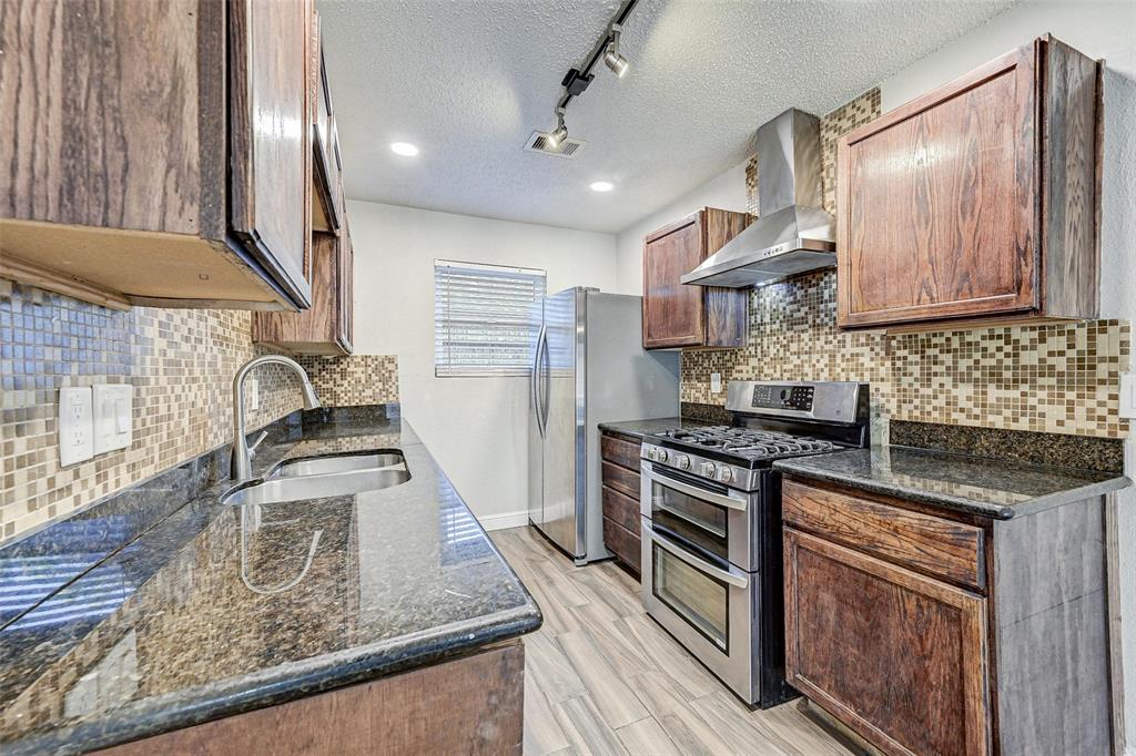 a kitchen with stainless steel appliances granite countertop a sink stove and refrigerator