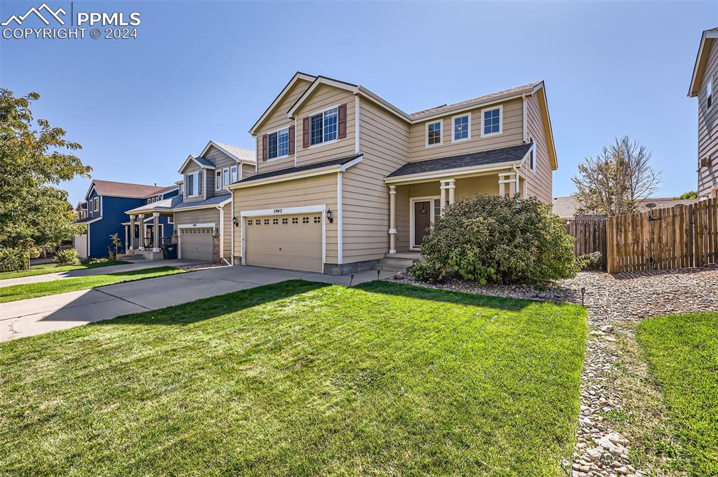 a front view of a house with yard and green space