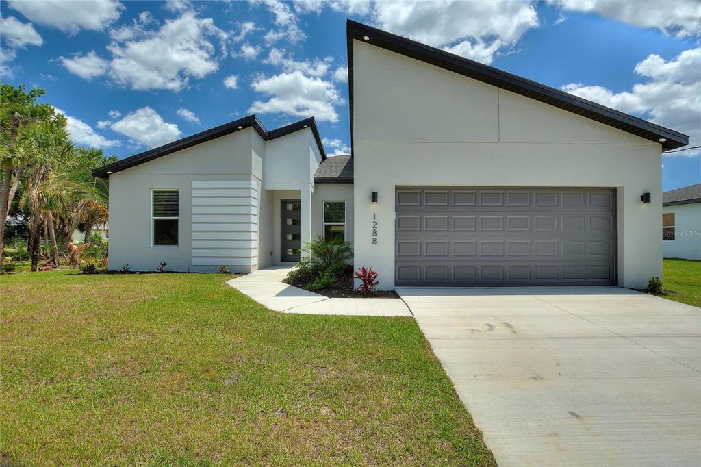 a front view of a house with a yard and garage