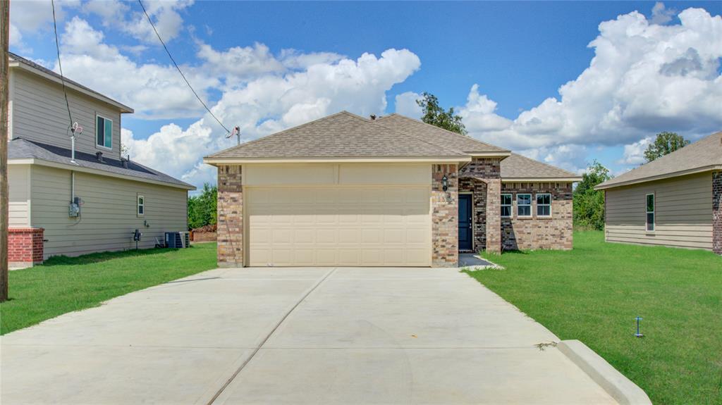 a view of a house with a yard and a garage