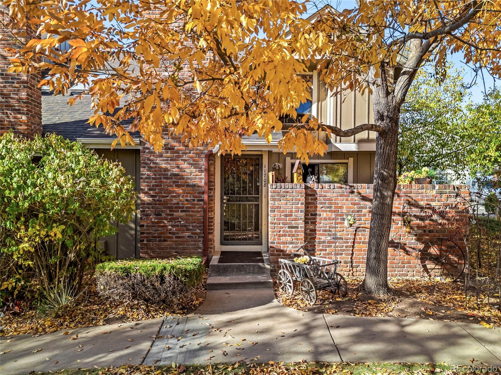 a view of a brick house with large windows and a tree