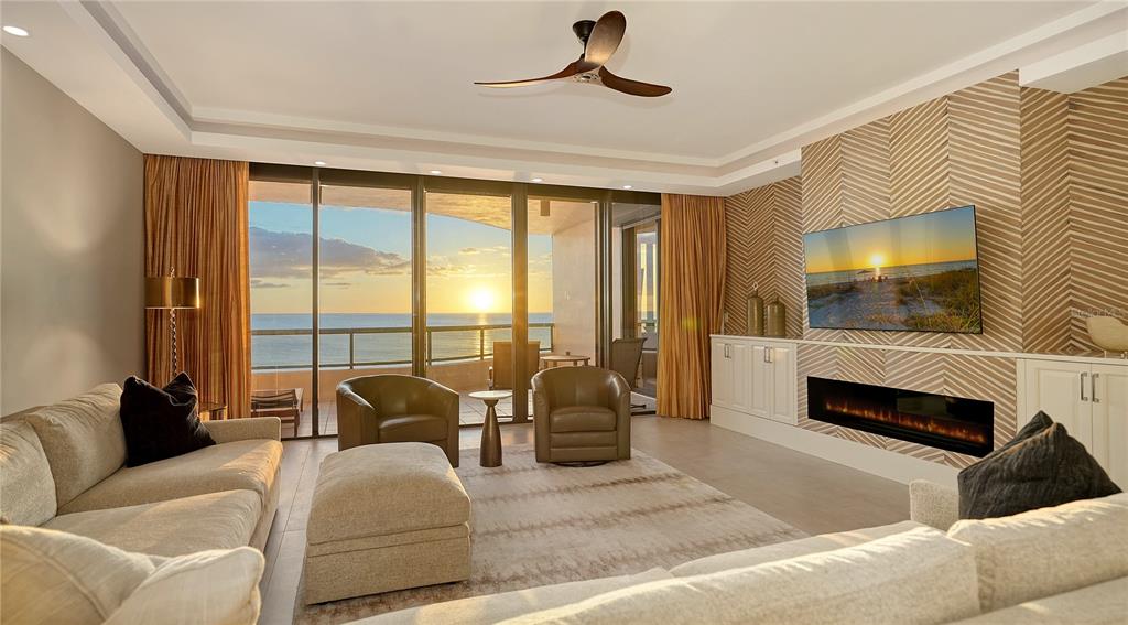 a living room with furniture a flat screen tv and a large window