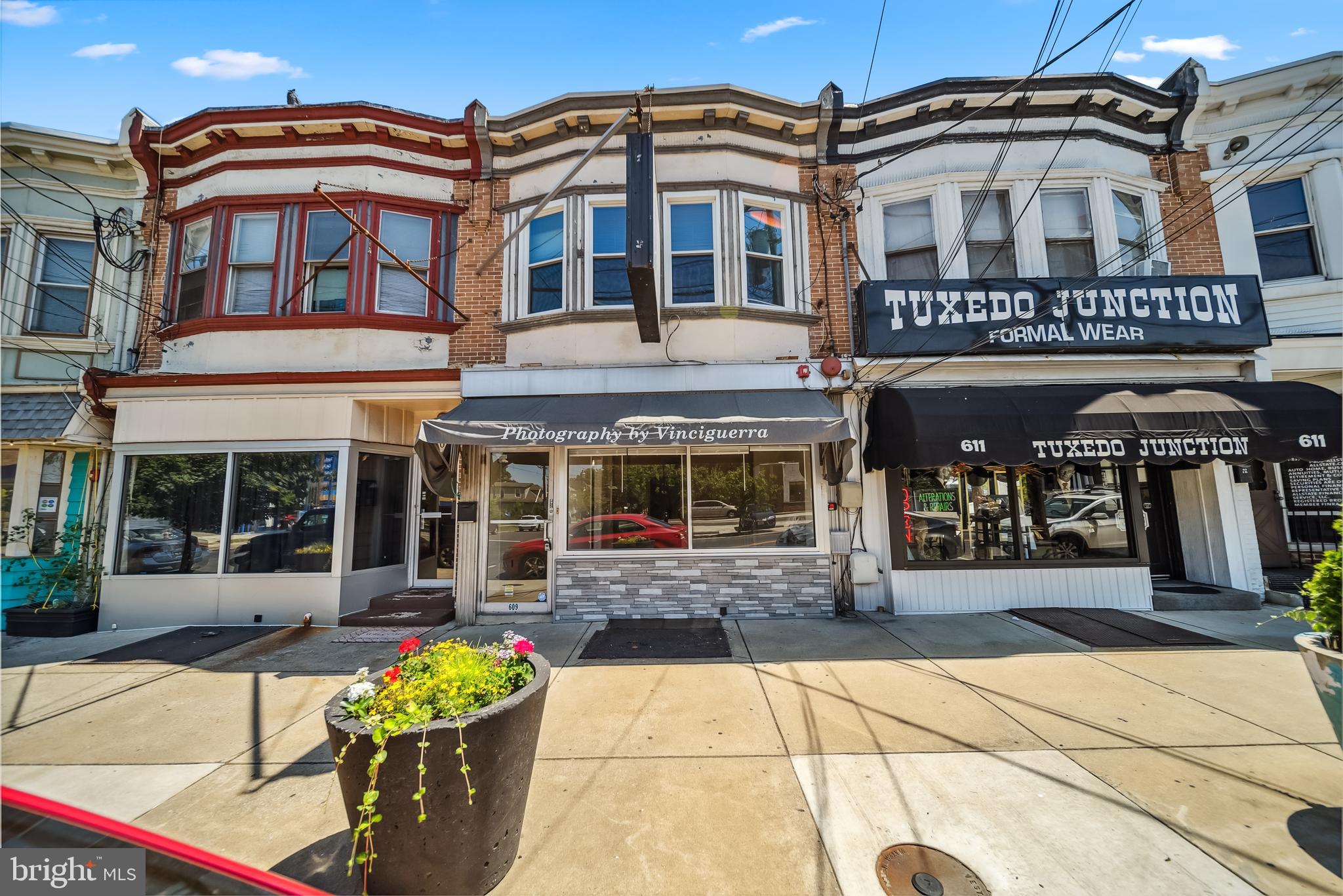 a front view of a building with outdoor seating and flowers