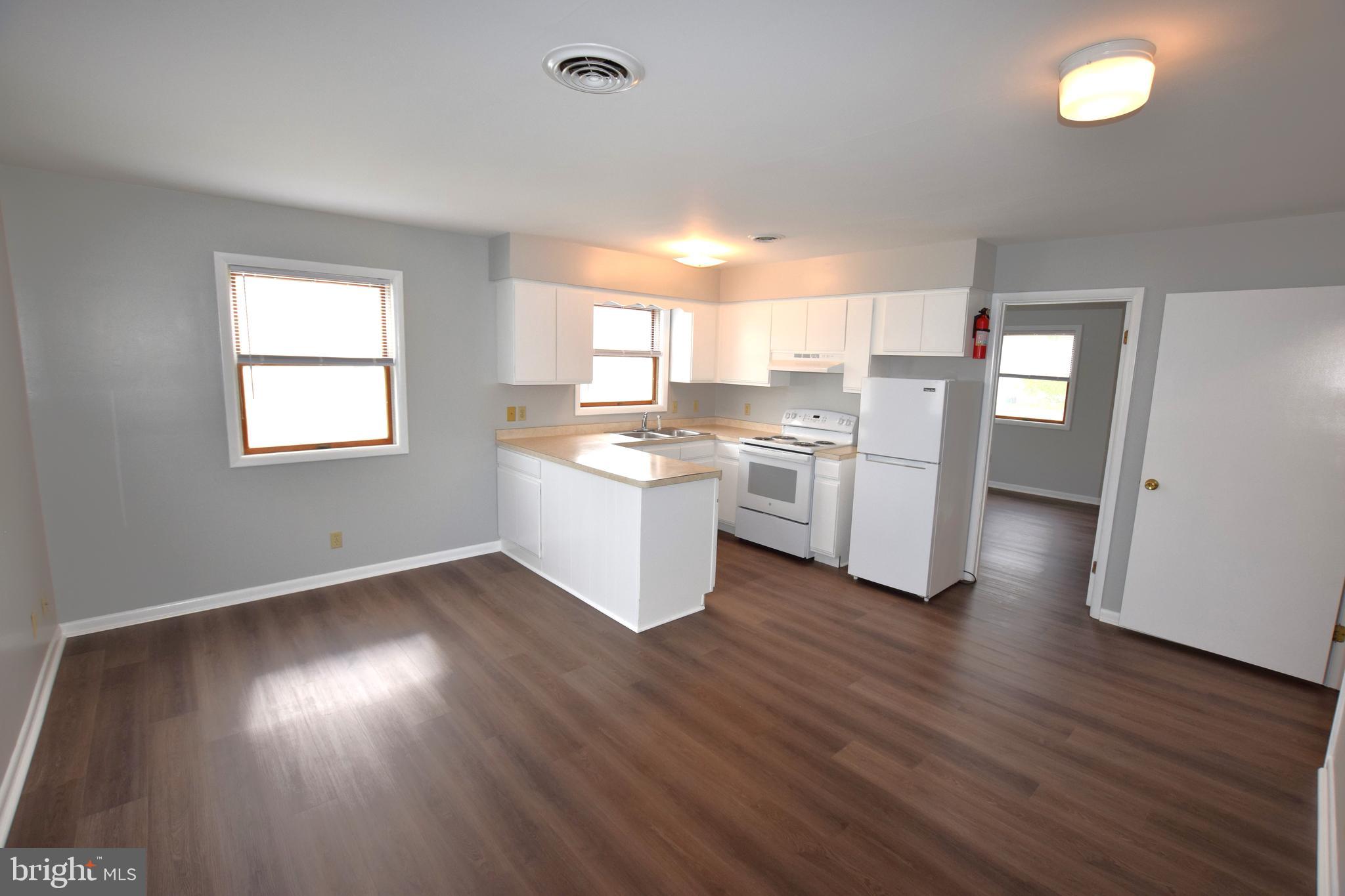 a kitchen with cabinets and wooden floor