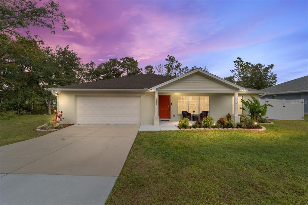 a front view of a house with a garden and yard