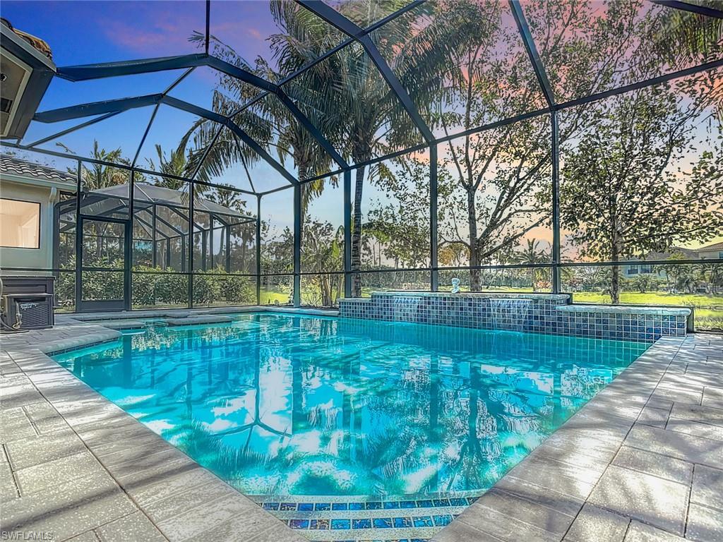 Pool at dusk featuring a patio and a lanai