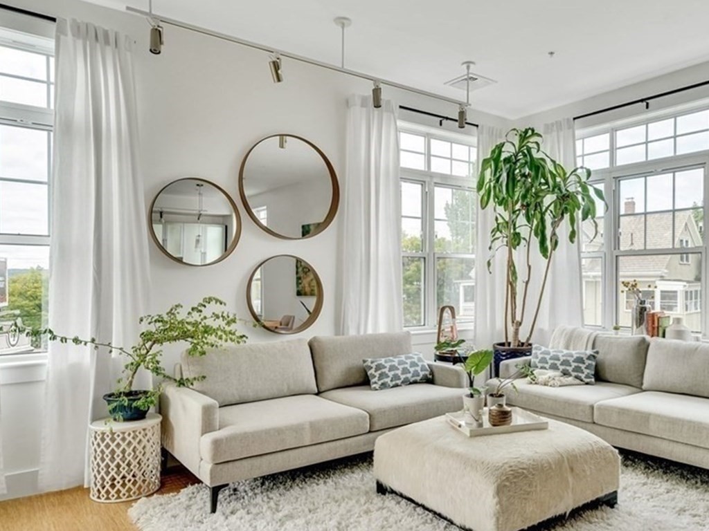 a living room with furniture a chandelier and a large window