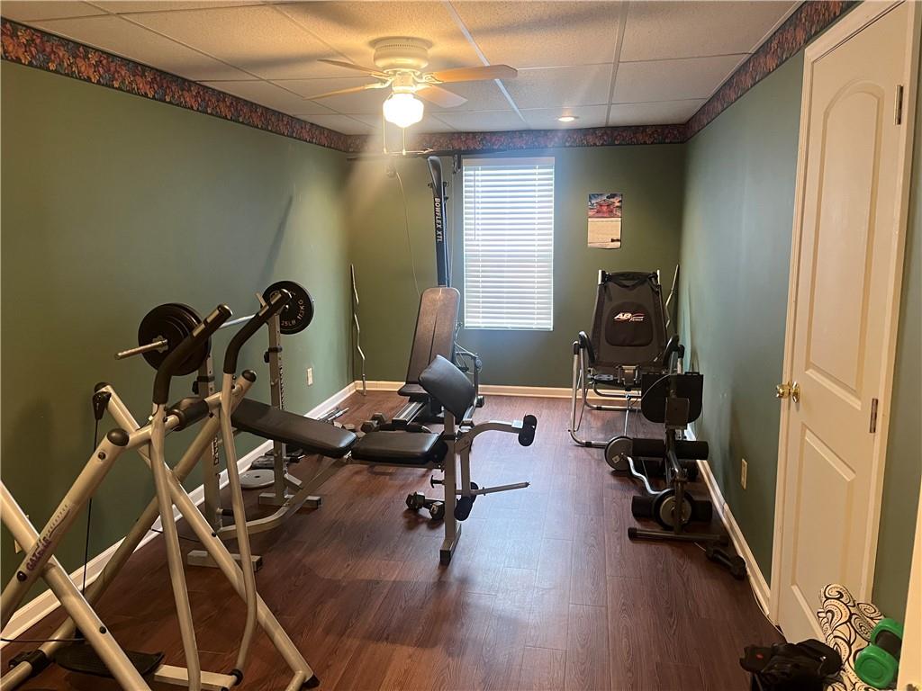 a room with gym equipment and wooden floor