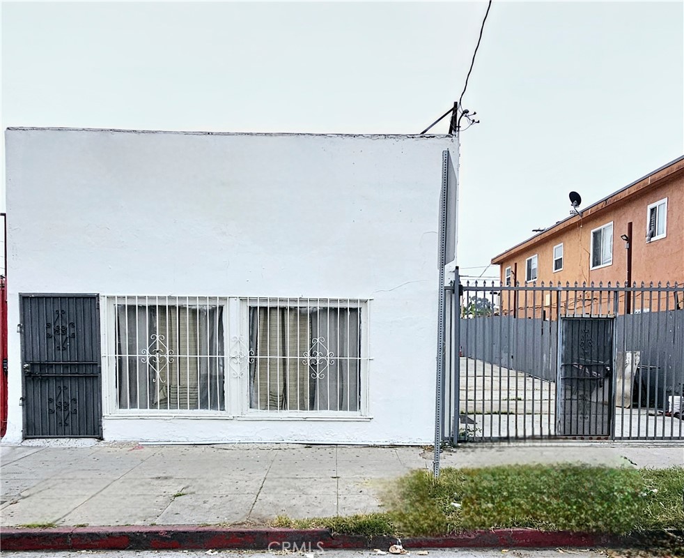 a view of a house with a small yard and wooden fence