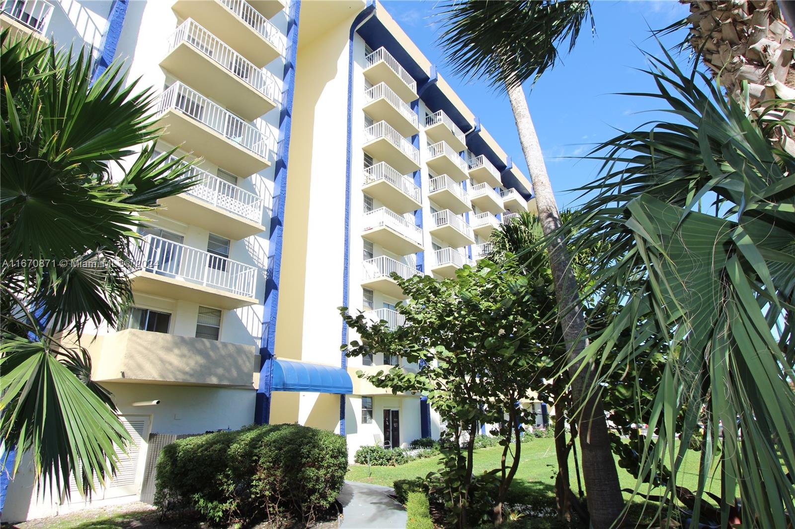 a front view of a multi story building with a palm trees