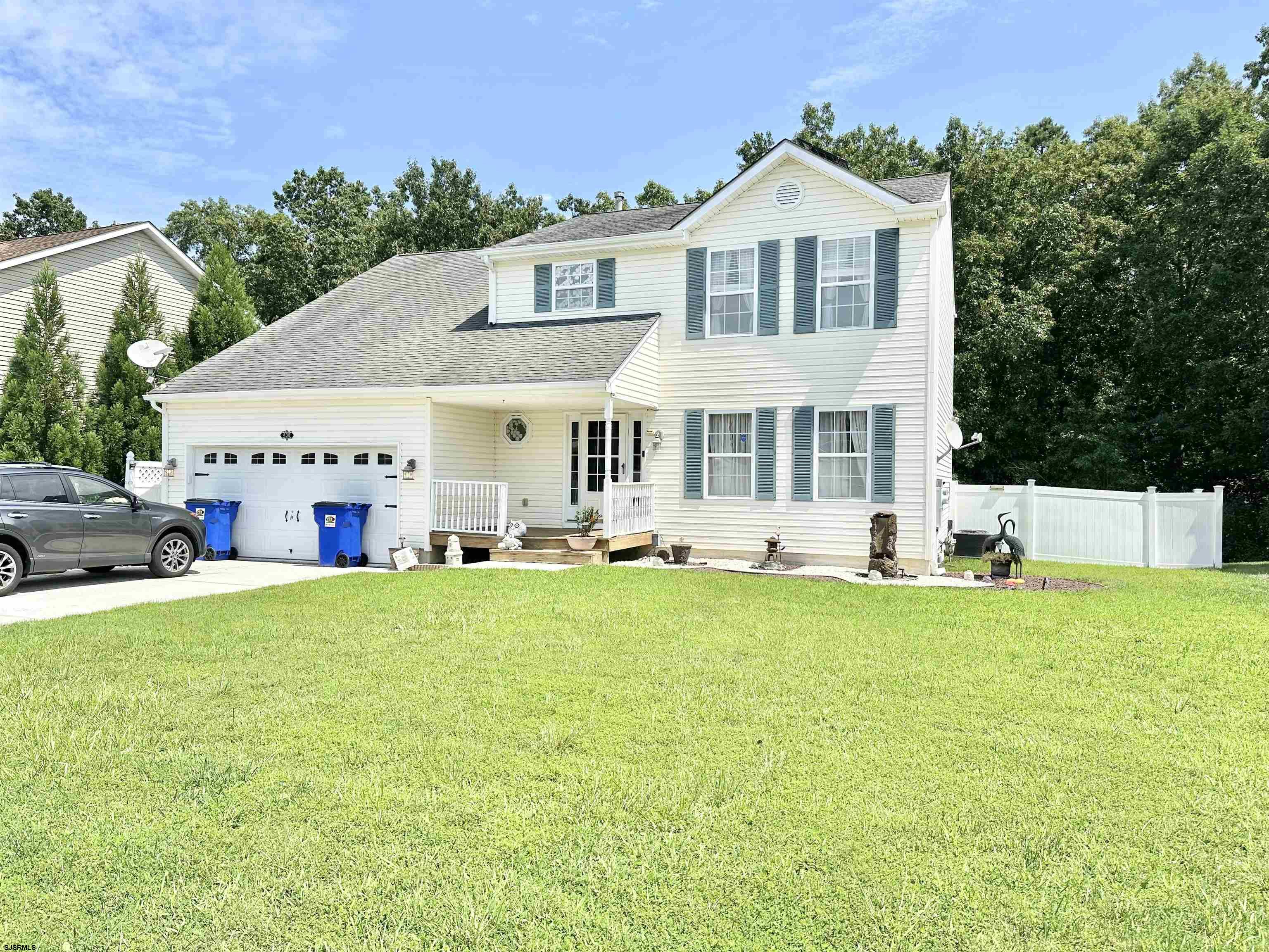 a front view of a house with yard and green space