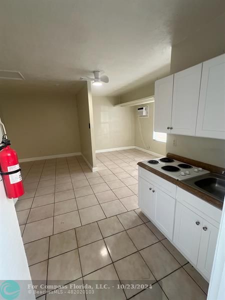 a kitchen with granite countertop a stove a sink and a shower