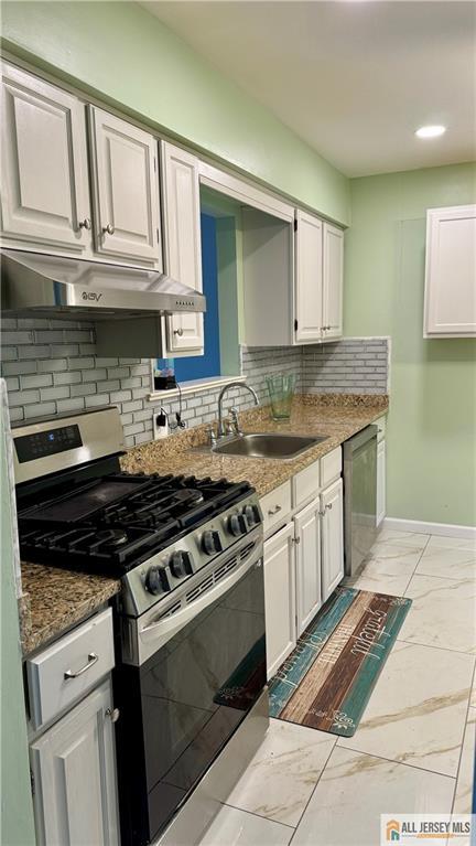 a kitchen with granite countertop a stove top oven cabinetry a chimney and cabinets