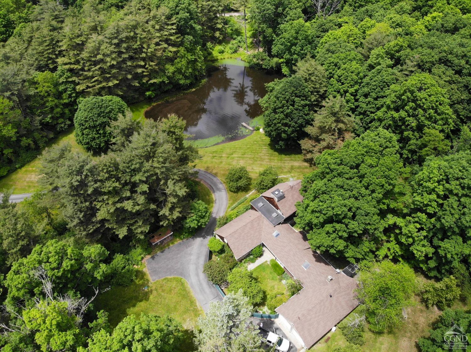 an aerial view of a house with a yard and lake view