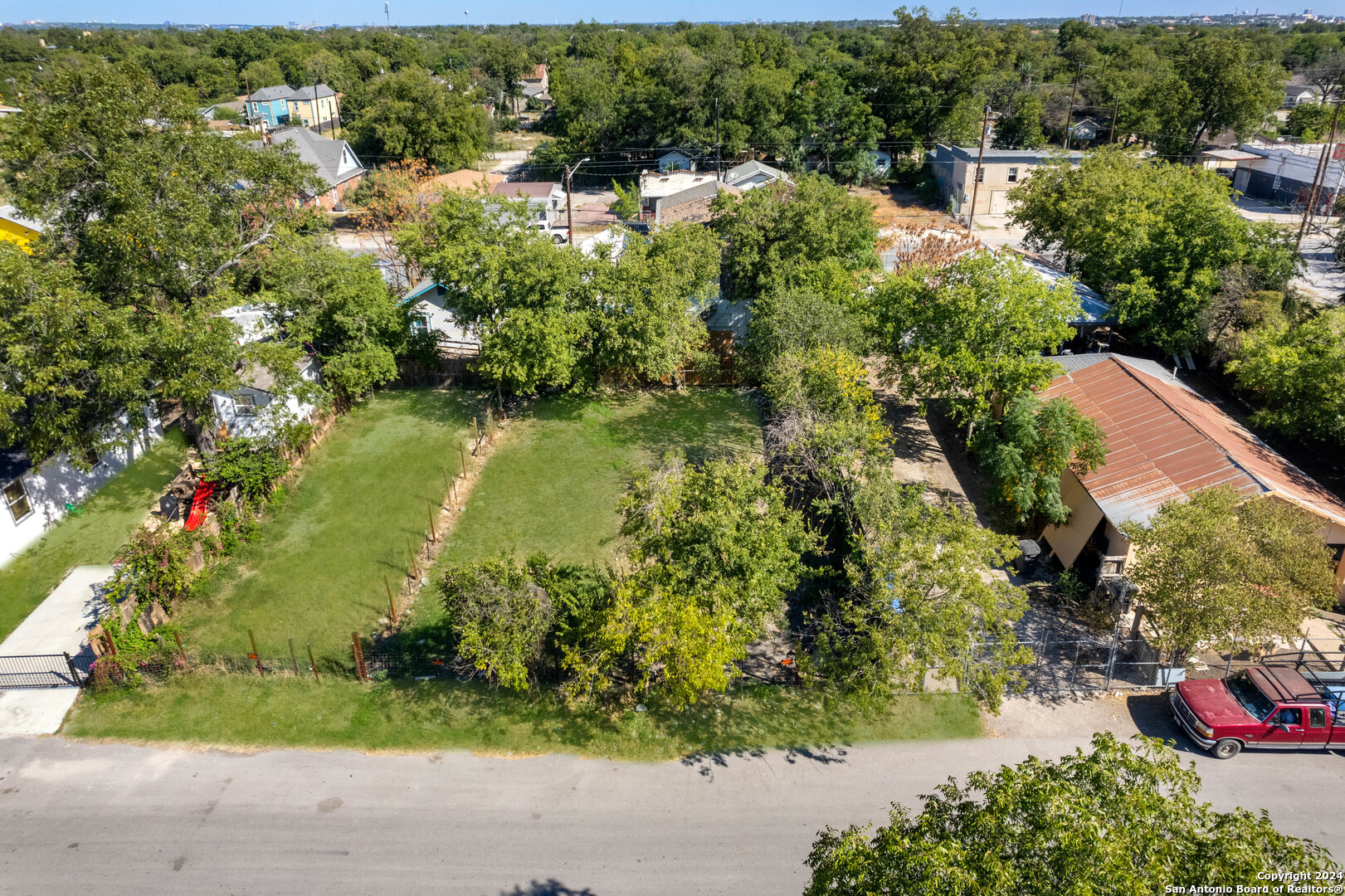 an aerial view of residential house with outdoor space and trees all around