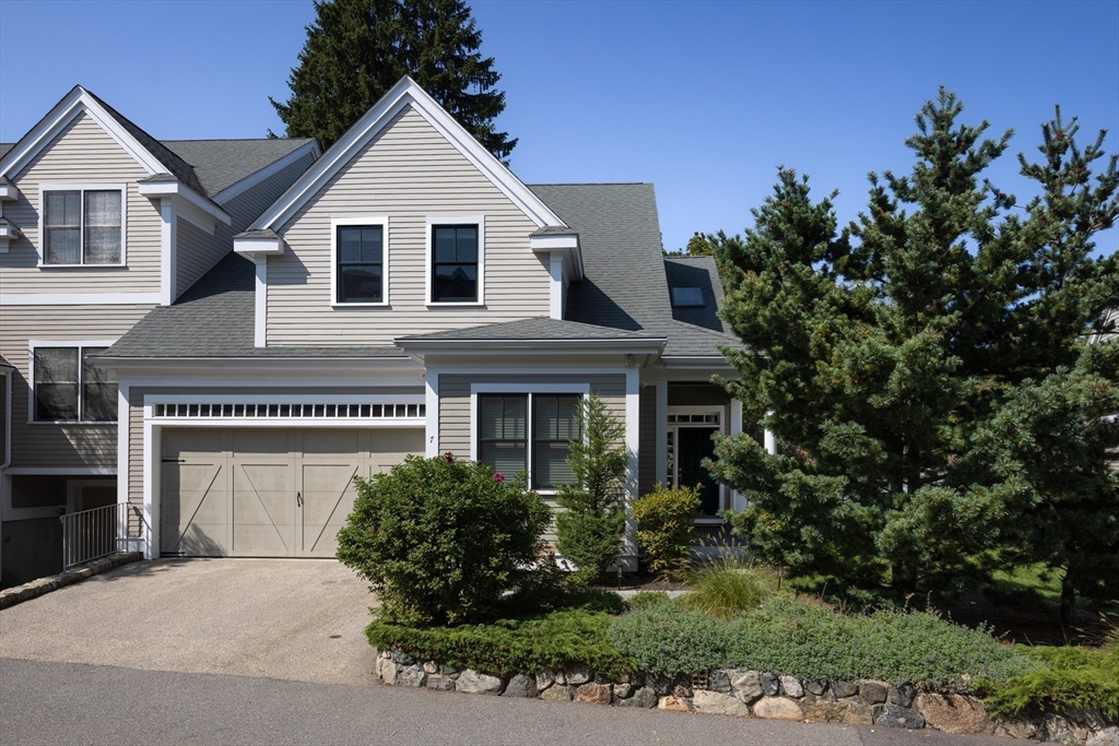 a view of a house with a yard and potted plants