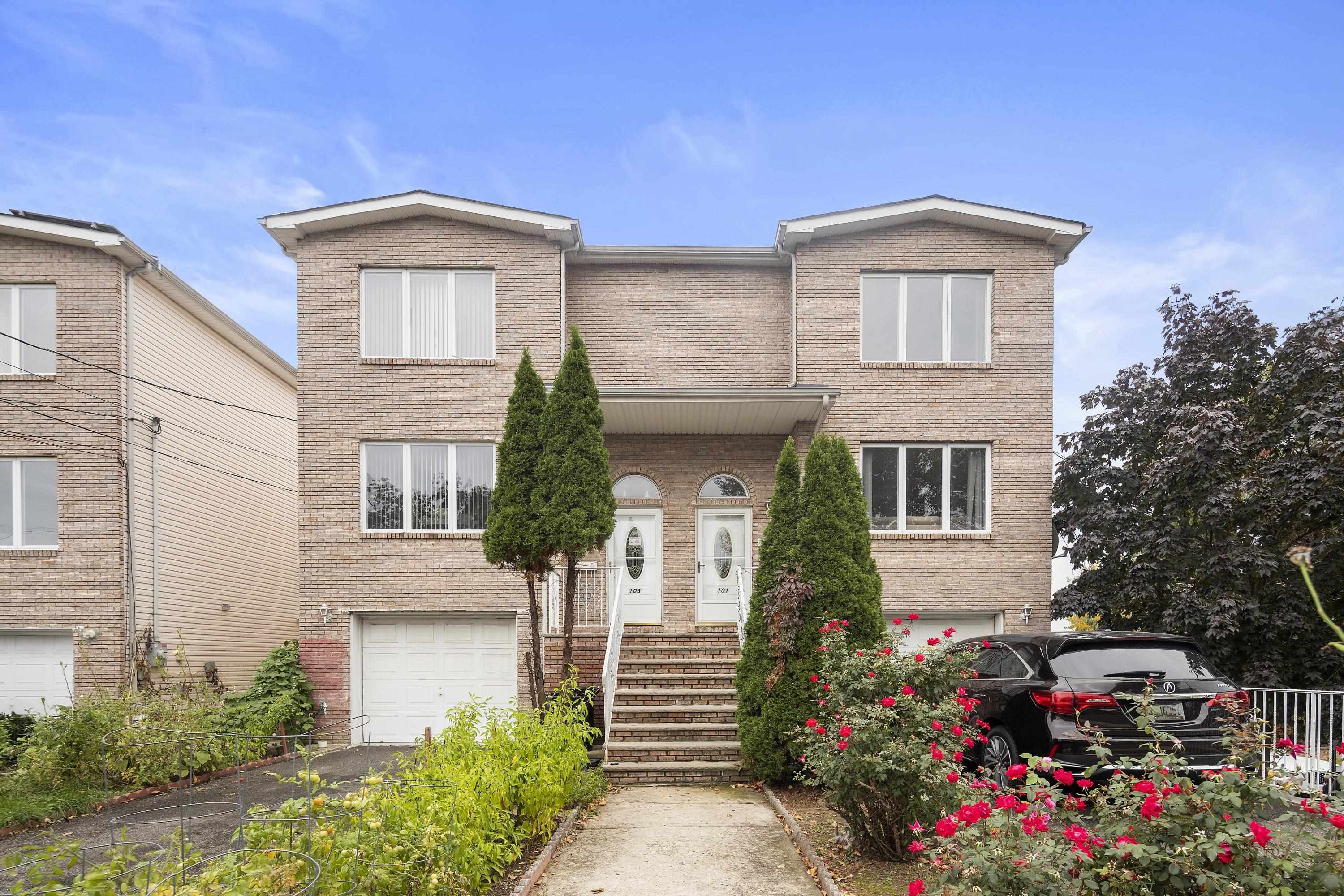 a front view of a house with a yard and potted plants