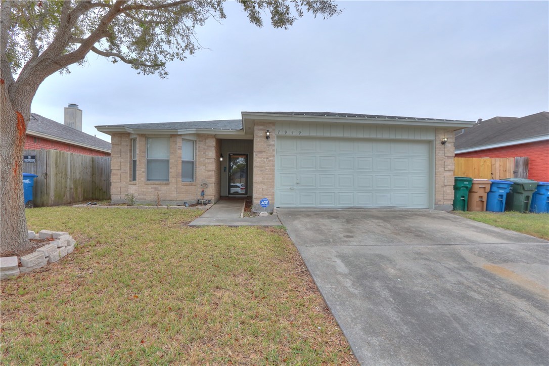 front view of a house with a yard and garage