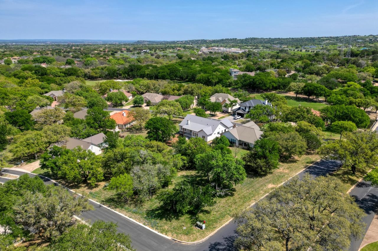 an aerial view of residential houses with outdoor space and trees