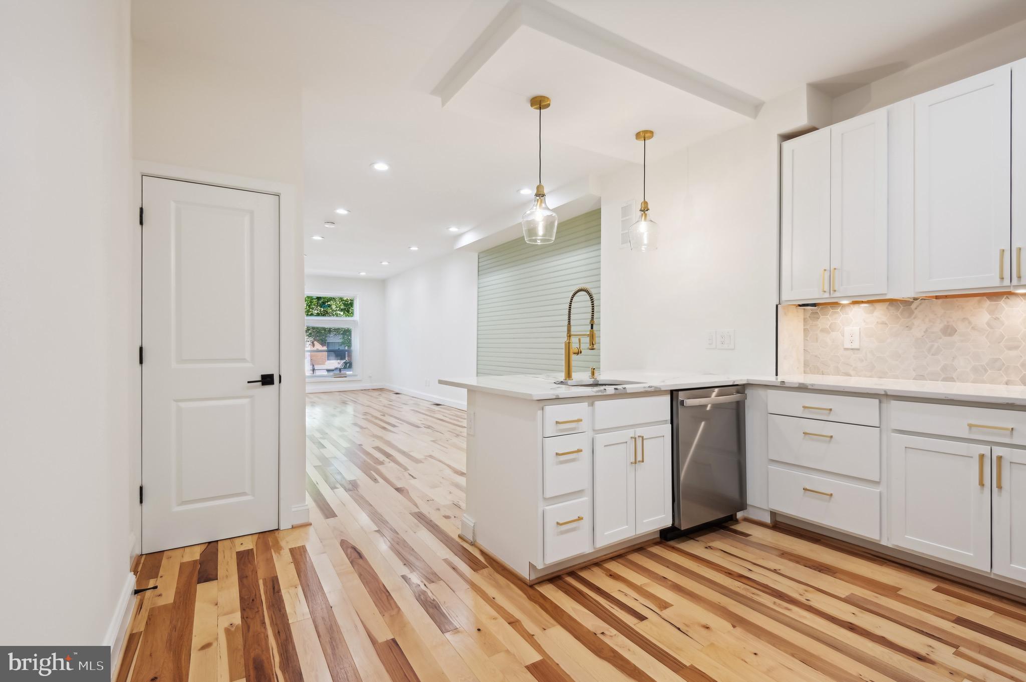 a kitchen with white cabinets and sink