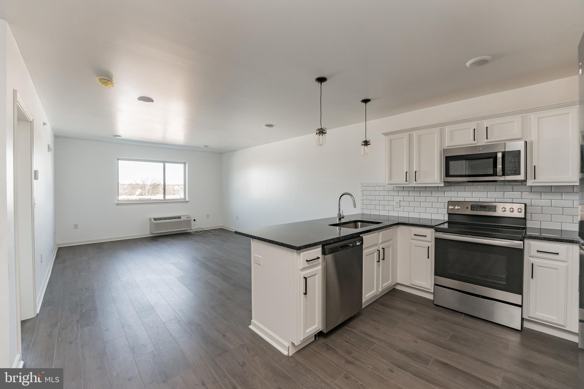 a kitchen with granite countertop a stove and a wooden floors