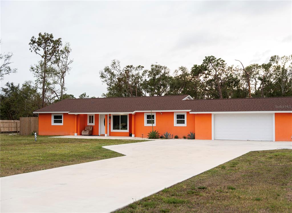 a front view of house with yard and trees in the background