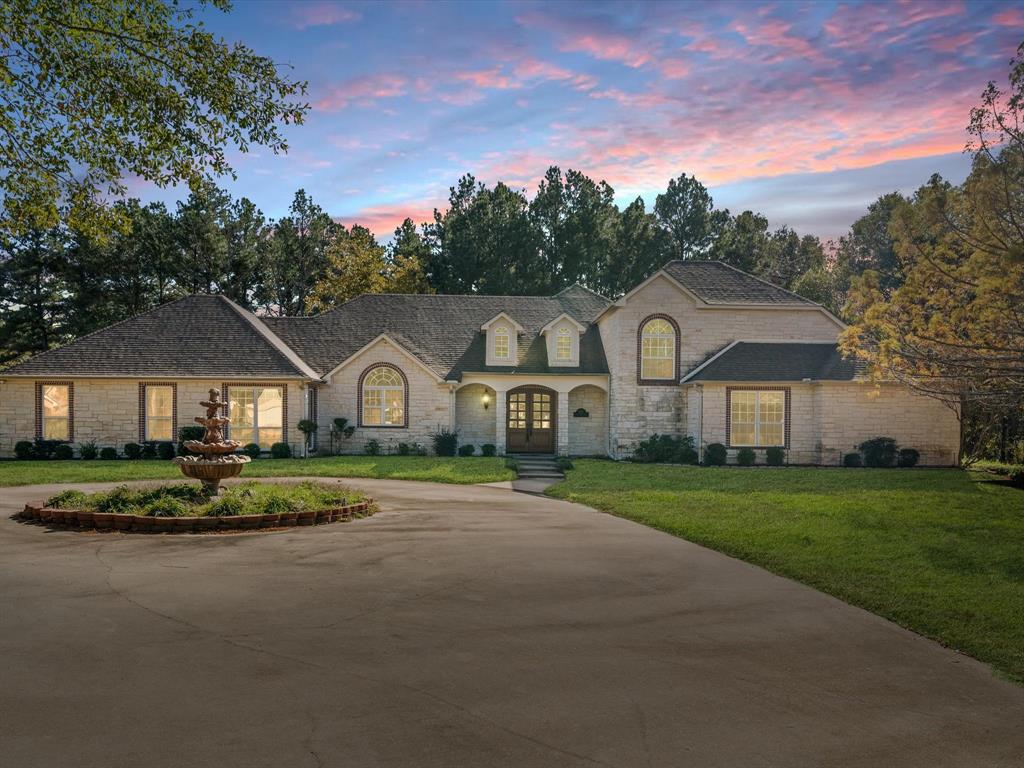 a front view of a house with a yard and trees